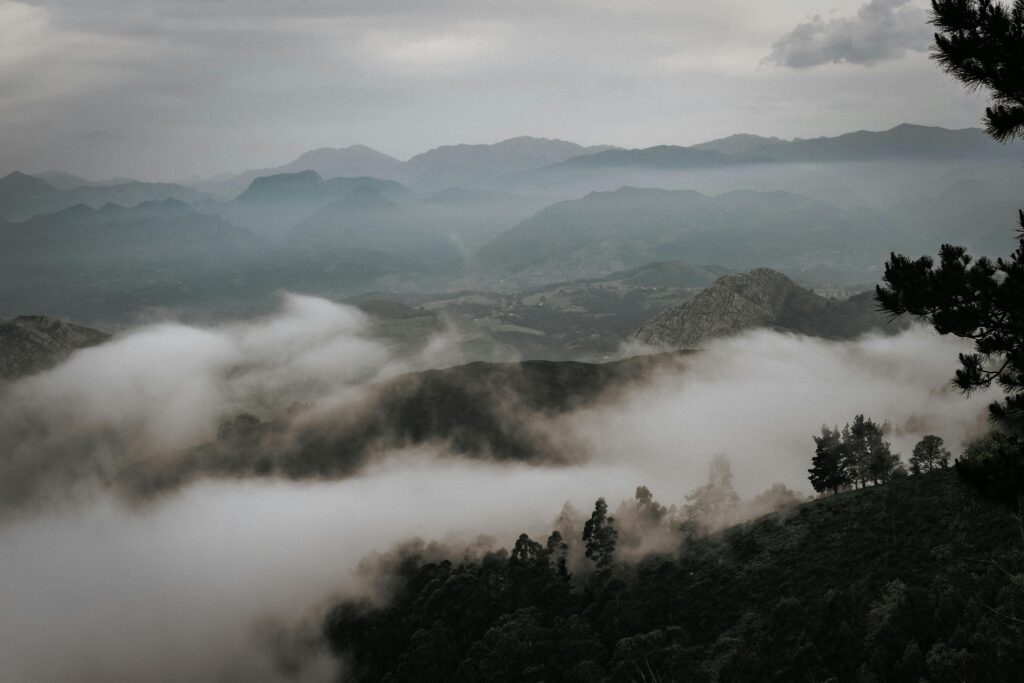 A breathtaking view of fog enveloping the mountains in Asturias, creating a serene and mystical atmosphere.